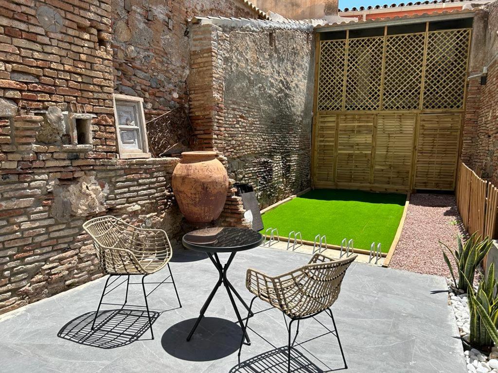 een patio met een tafel en stoelen en een groen gazon bij Málaga centro estudio precioso 4 in Málaga