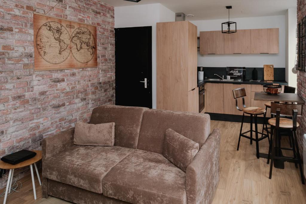 a living room with a couch and a kitchen at Appartement 2 pièces L'industriel en centre-ville de Cambrai in Cambrai