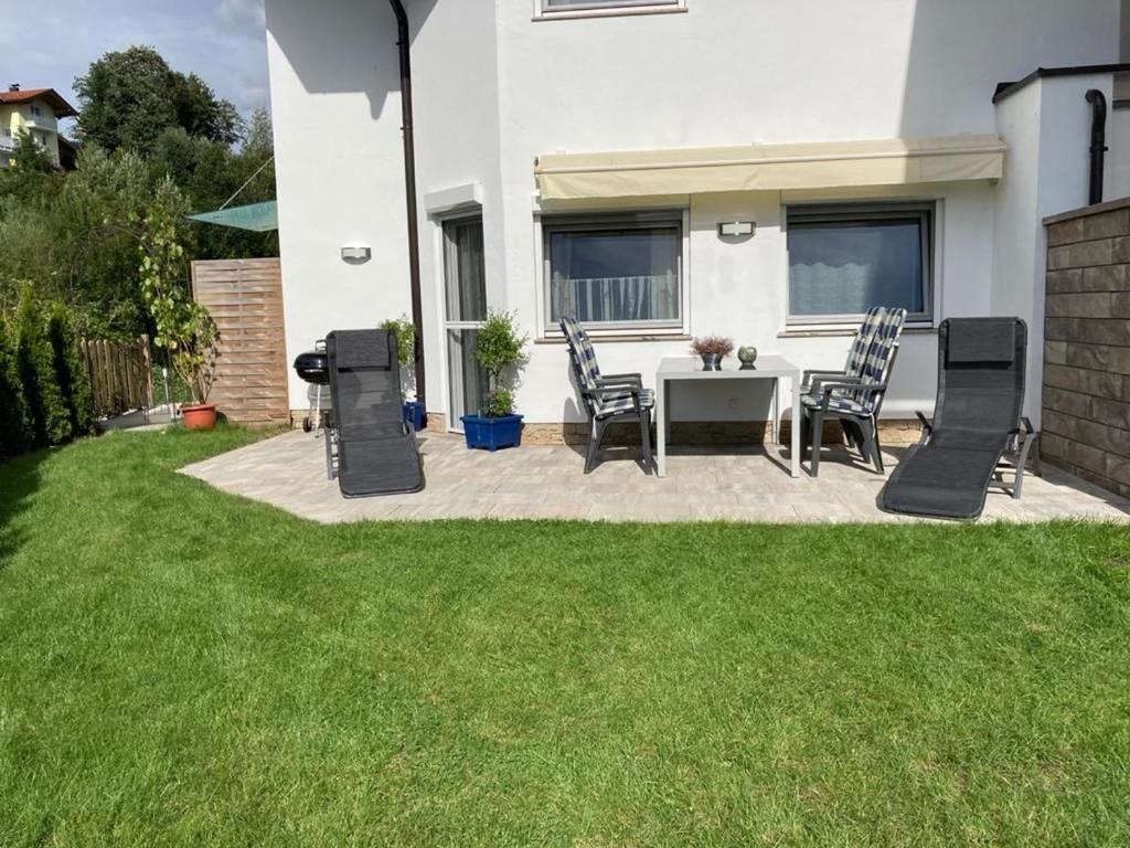 a patio with a table and chairs in a yard at Appartement Mühltal in Westendorf