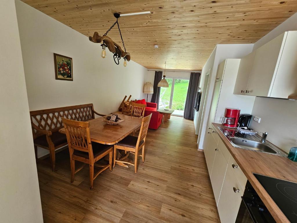 cocina y comedor con mesa y sillas en Rustikale Ferienwohnung auf Rups Hof, en Oberhöcking