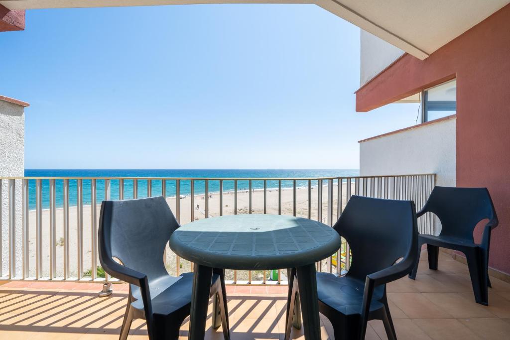 Edificio Victoria 5º-7ª في La Playa: طاولة وكراسي على شرفة مع المحيط
