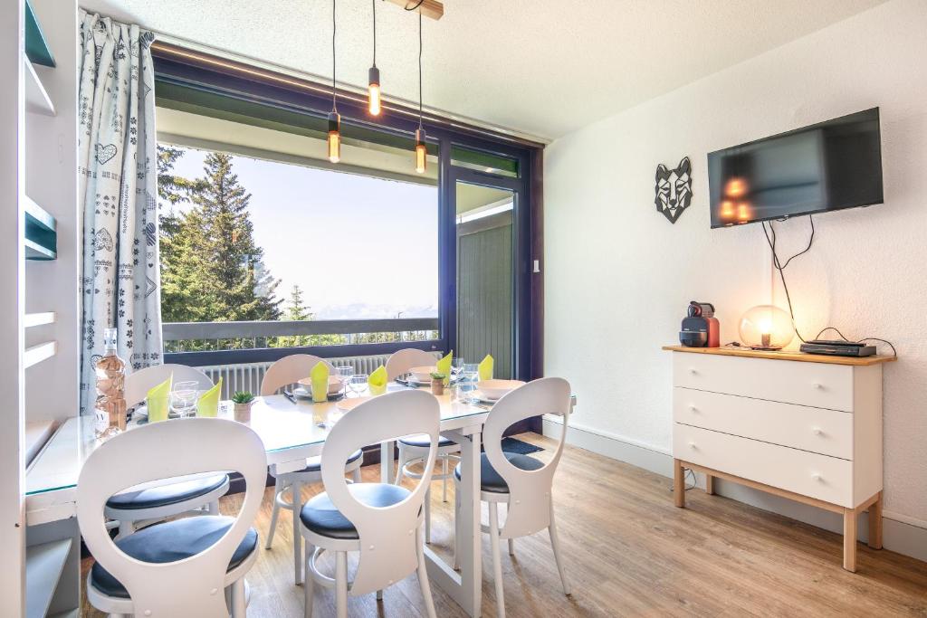 a dining room with a table and chairs and a window at L'Ascension - Studio vue montagne in Chamrousse