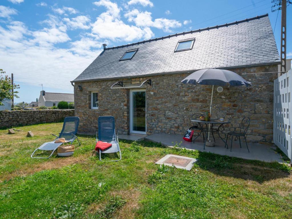 a stone house with two chairs and an umbrella at Holiday Home La petite Iroise by Interhome in Plogoff