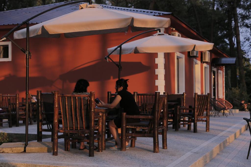 two women sitting at a table under an umbrella at Oxygen Hotel in Shekvetili