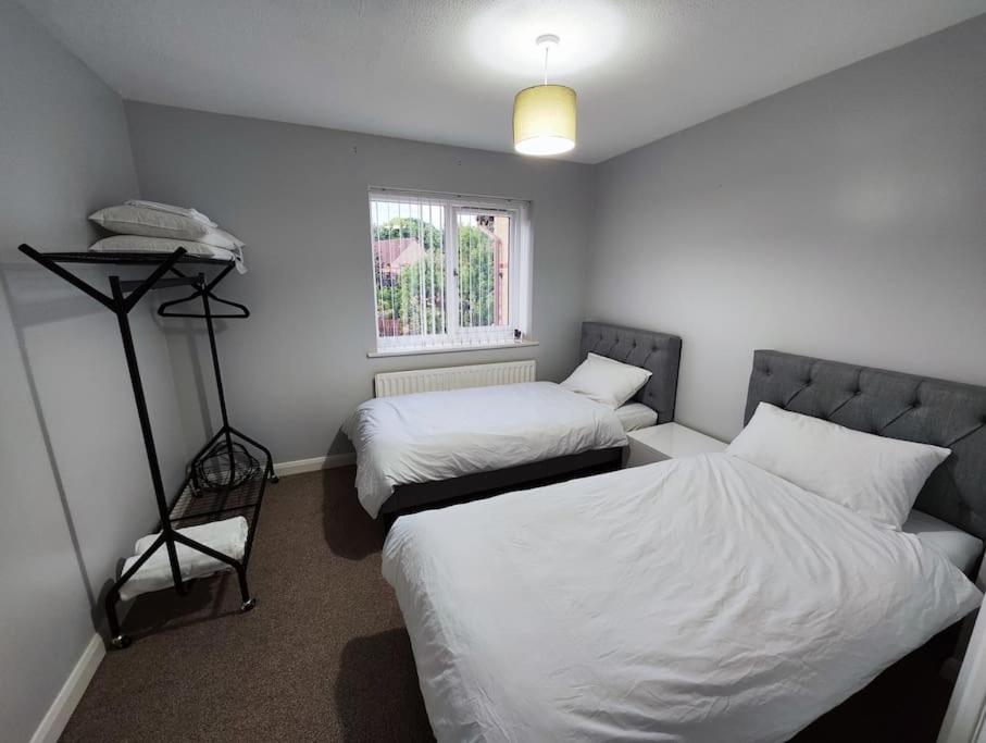 a small room with two beds and a window at Harmony in Bicester in Bicester