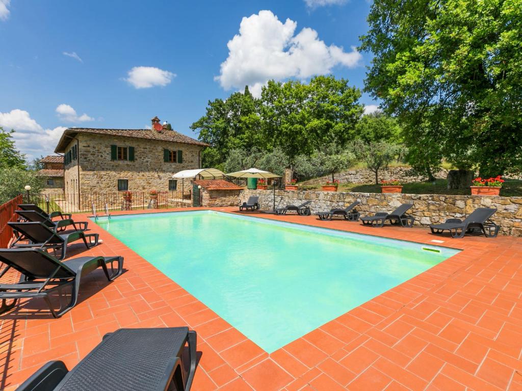 einen Pool mit Stühlen und ein Haus in der Unterkunft Holiday Home La Querciolaia by Interhome in Pieve a Presciano