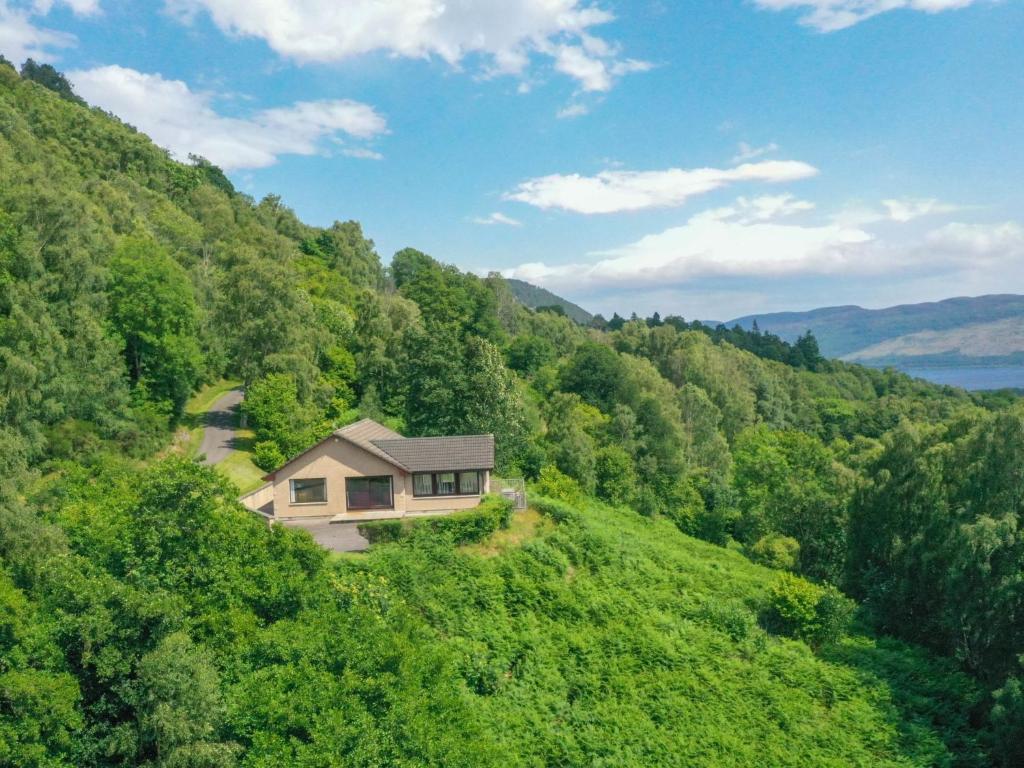 una casa en medio de una colina verde en Holiday Home Achmony Number 7 by Interhome, en Drumnadrochit