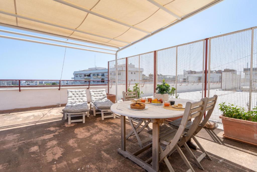 Habitación con balcón con mesa y sillas. en Bright Studio with terrace & parking, en Bari