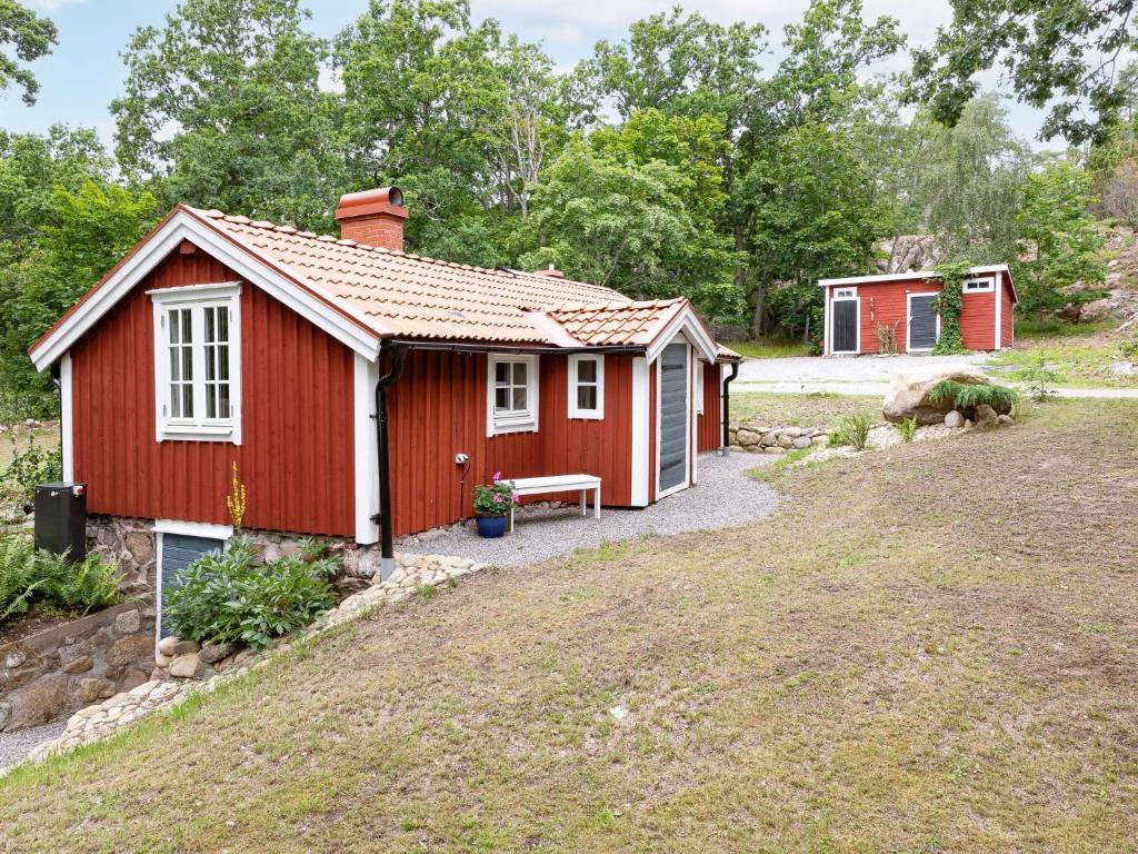 a red cottage with a bench in a yard at Chalet Jennys - B in JÃ¤mjÃ¶