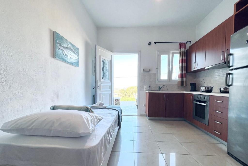 a kitchen with a bed in the middle of a room at Four S Apartments in Mikonos
