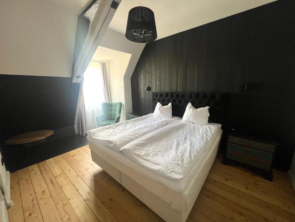 1 dormitorio con 1 cama con sábanas blancas y ventana en Rezidence Wannas Self Check in, en Sigulda