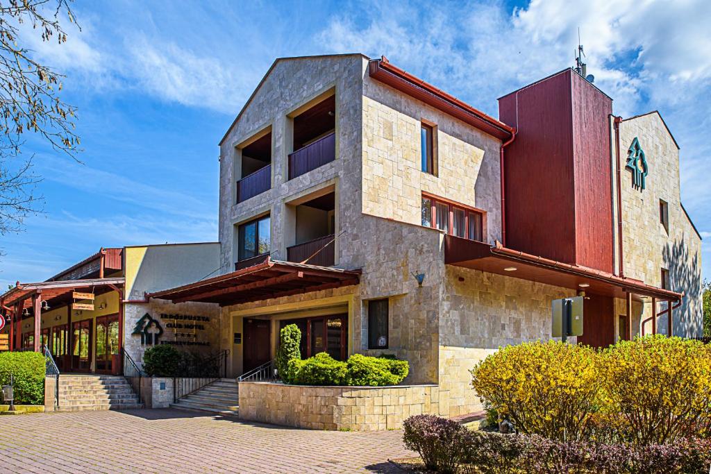 a large building with a red at Erdőspuszta Club Hotel Fenyves in Debrecen