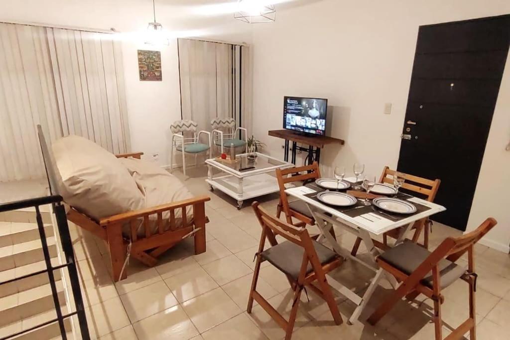 ein Wohnzimmer mit einem Tisch und einem Sofa in der Unterkunft Departamento con estilo en Barrio Bombal in Godoy Cruz