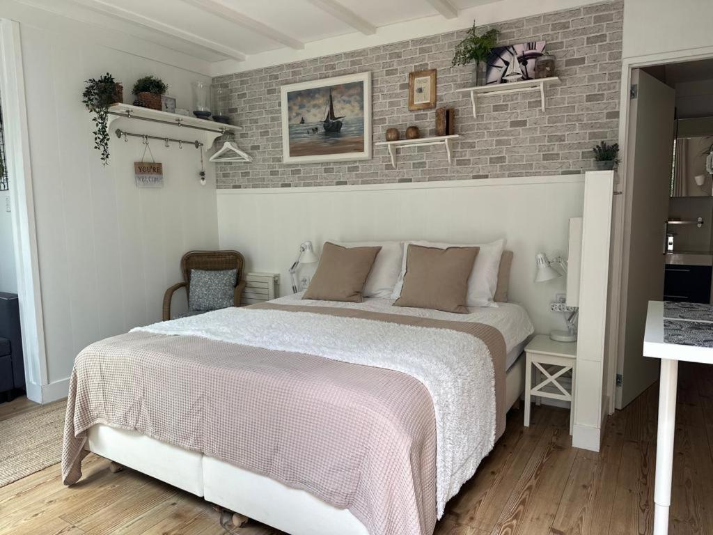 a bedroom with a bed and a brick wall at Beach Holiday Appartements in Dirkshorn