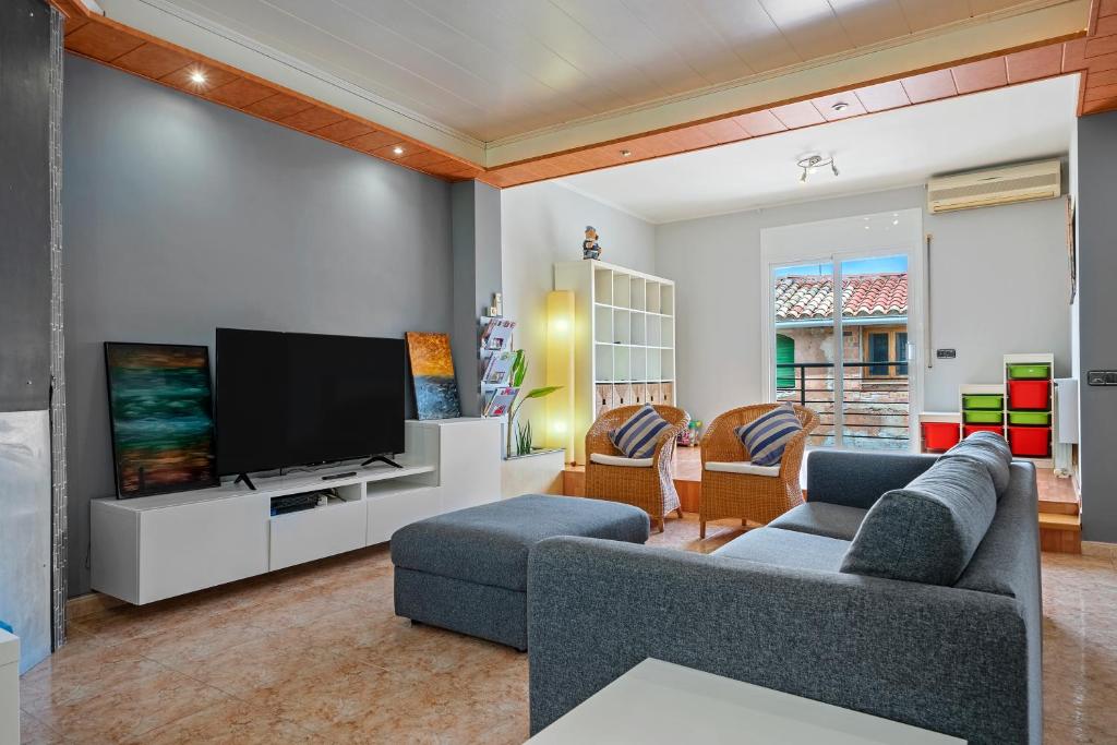 a living room with two couches and a flat screen tv at Ca la Francina in Torre del Español