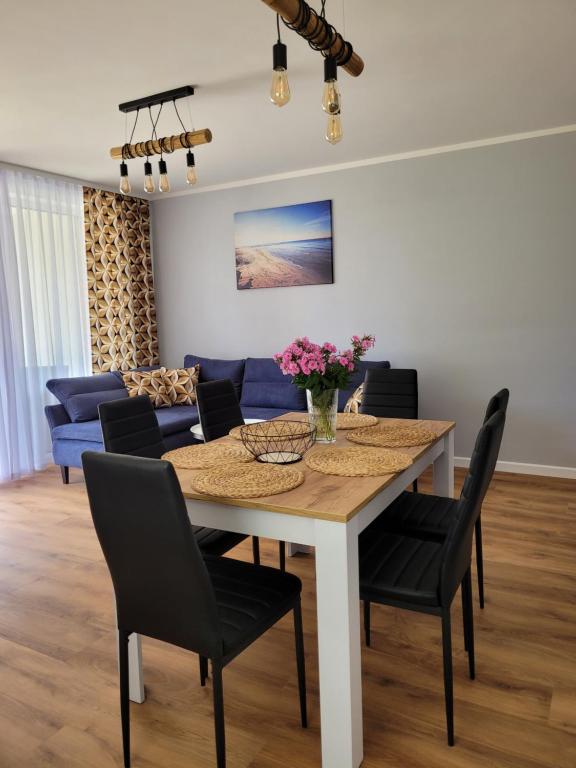 a dining room with a table and chairs at Apartament Wśród Kasztanów in Puck
