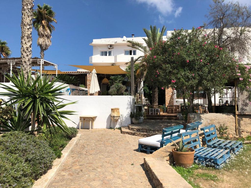eine Terrasse mit zwei blauen Bänken und einem Gebäude in der Unterkunft Hostal Illes Pitiüses in Sant Ferran de Ses Roques