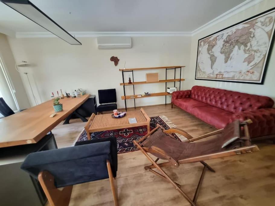 een woonkamer met een rode bank en een tafel bij tria house in Antalya