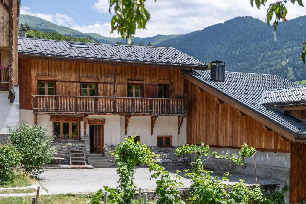 a large wooden house with a balcony at la maison des cerries in Hautecour