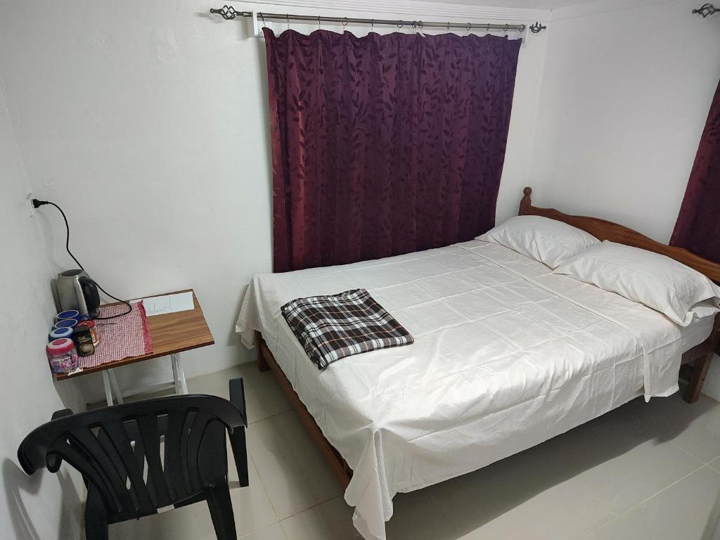 a bedroom with a bed and a table and a chair at Town Centre Stays in Nadi