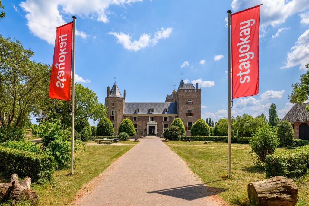 a house with two red flags in front of it at Stayokay Hostel Heemskerk in Heemskerk