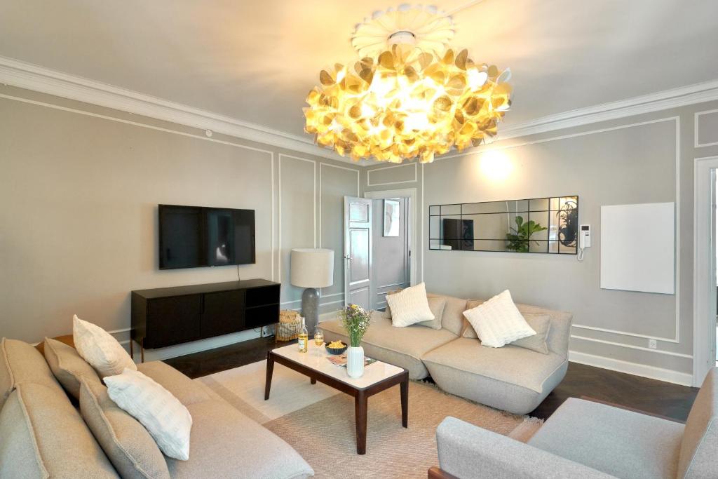a living room with a couch and a chandelier at Stylish 4 Bedroom flat in CPH City in Copenhagen