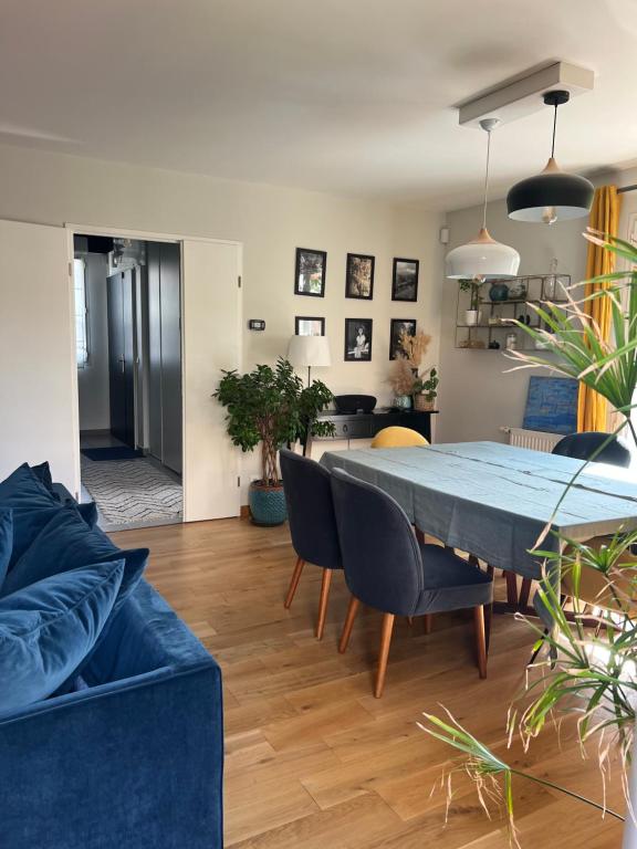 sala de estar con mesa azul y sillas en Maison Chessy, en Chessy