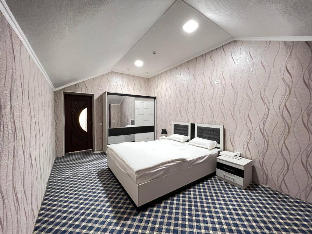 een slaapkamer met een groot wit bed in een kamer bij Orom Hotel Fergana in Fergana