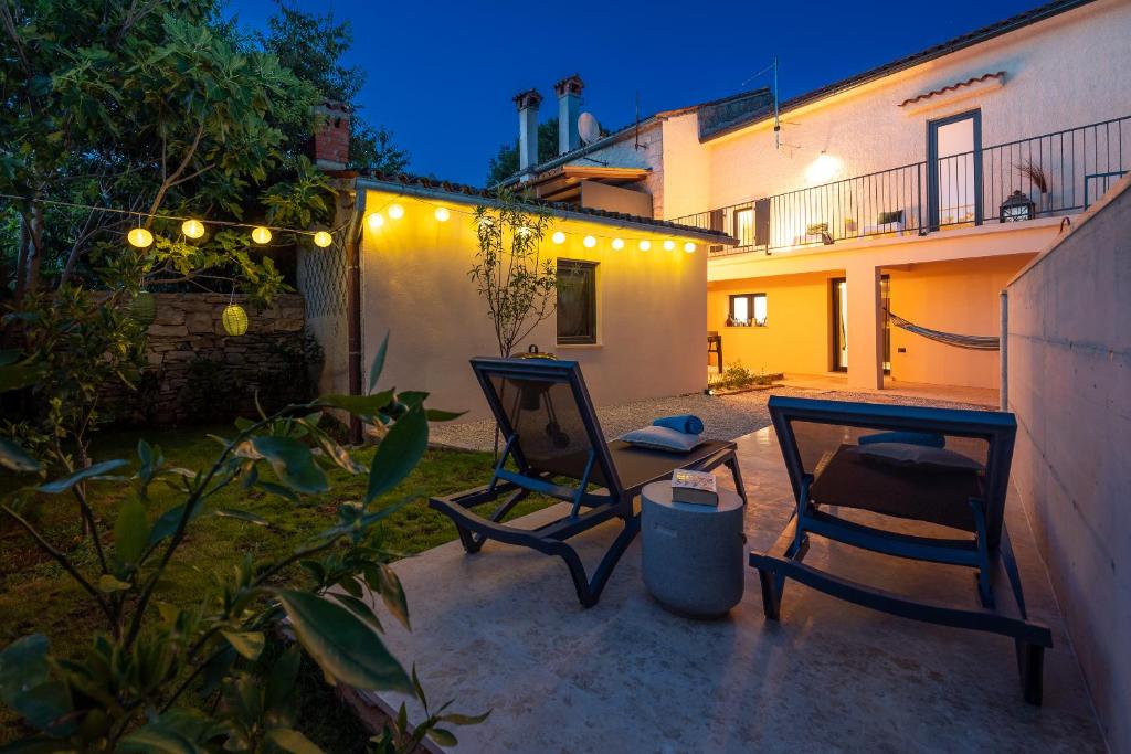 two chairs and a table on a patio at night at Villa Giorgio Juršići by IstriaLux in Svetvinčenat