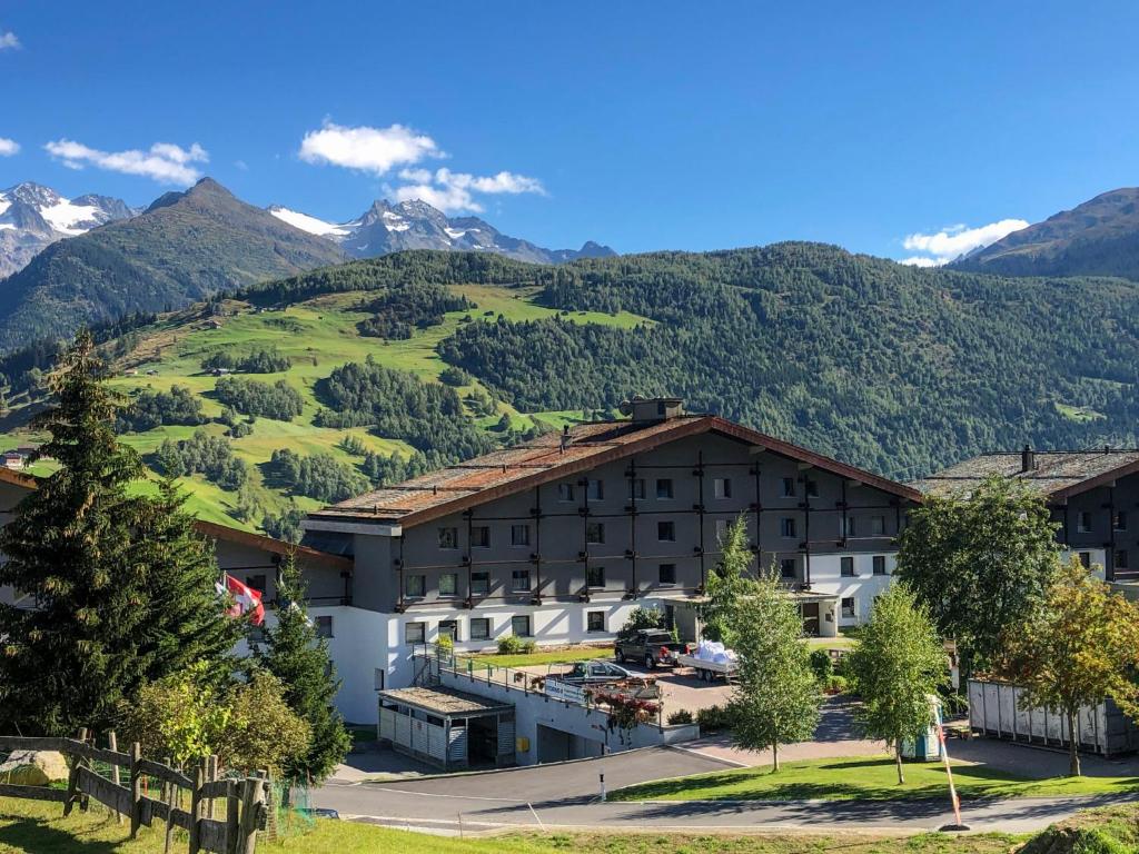 a hotel with mountains in the background at Apartment Utoring Acletta-1 by Interhome in Disentis