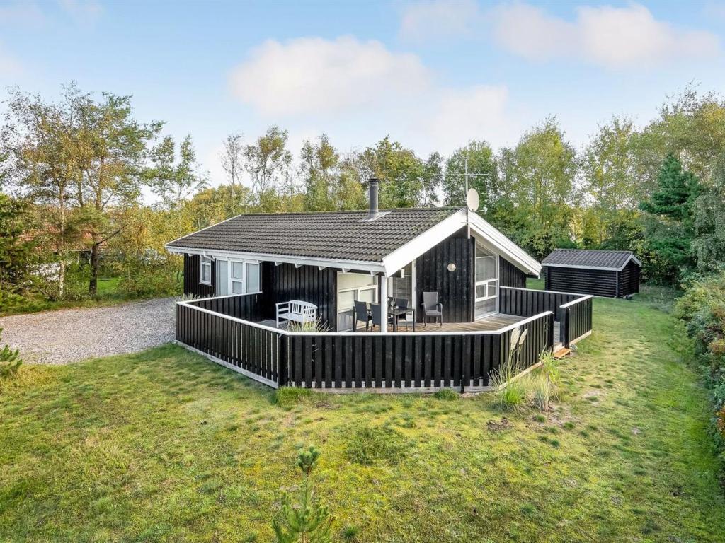 a house with a large deck in a yard at Holiday Home Alvy - 200m from the sea in Djursland and Mols by Interhome in Ebeltoft