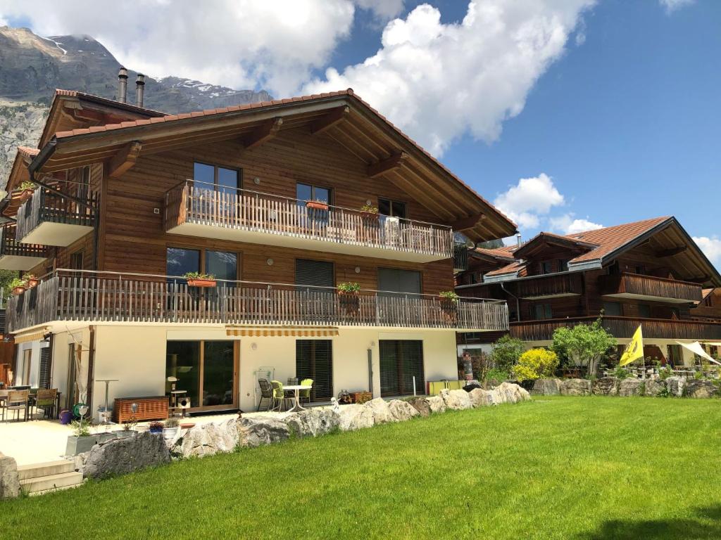 a large house with a lawn in front of it at Apartment beim Ahorn by Interhome in Kandersteg
