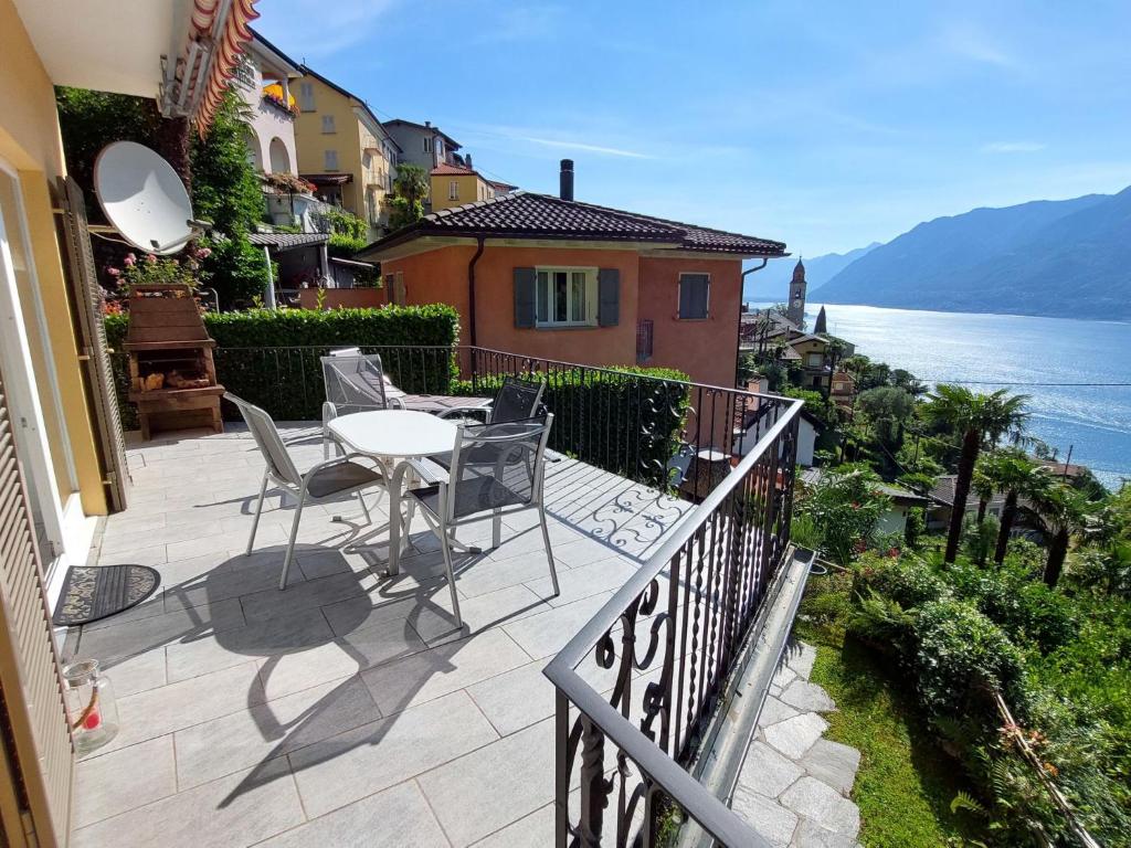 a balcony of a house with a table and chairs at Apartment Mulino Vecchio by Interhome in Ronco s/Ascona - Porto Ronco