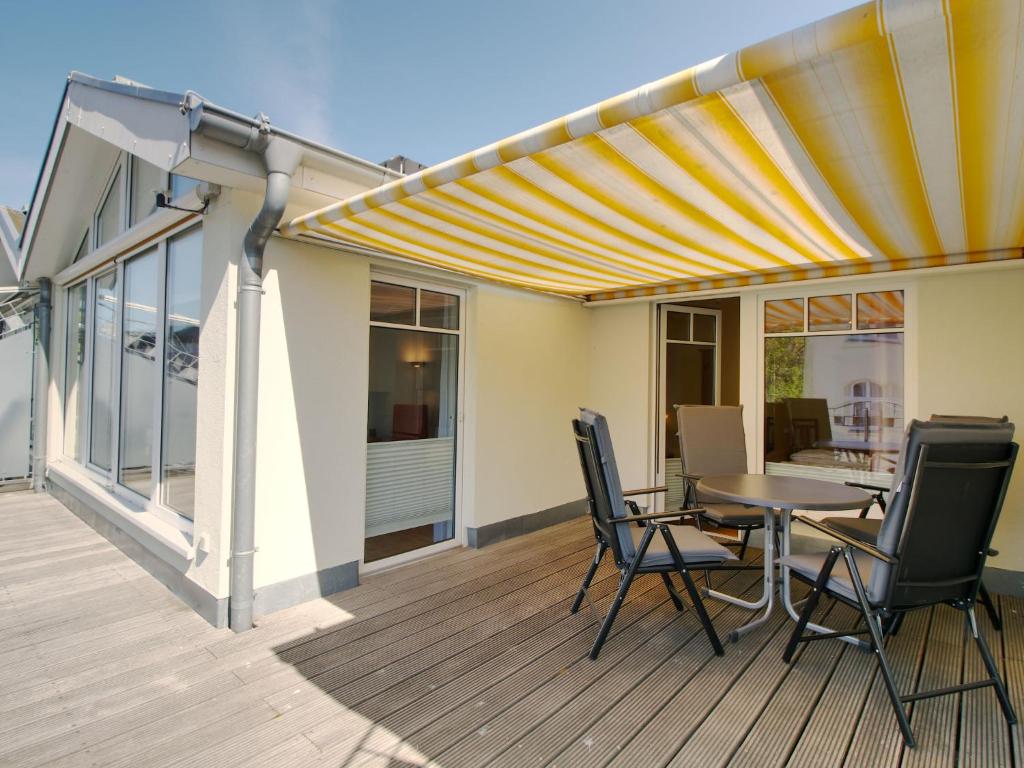 Un patio con una mesa y sillas en una terraza. en Apartment Luise von Preußen - App- 205 by Interhome, en Zinnowitz