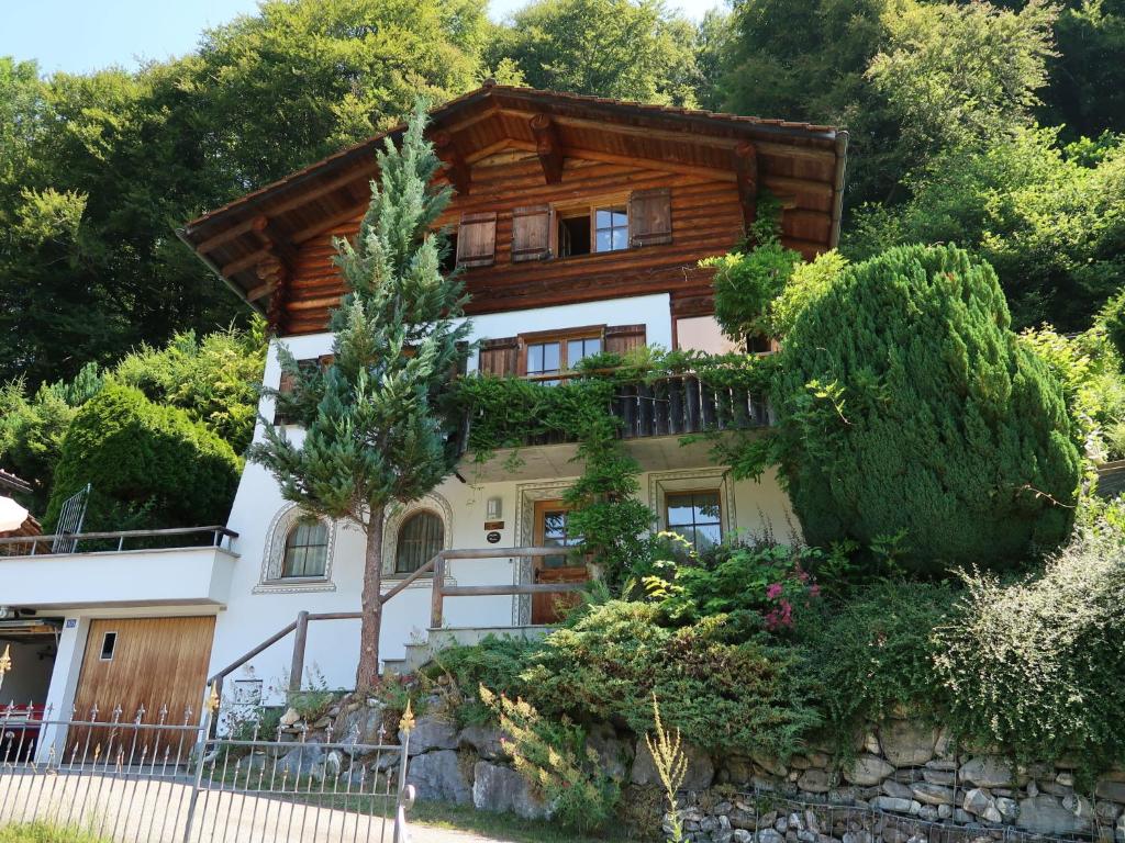 una casa en una colina con árboles y arbustos en Holiday Home Chalet Bergnest by Interhome, en Pragg-Jenaz