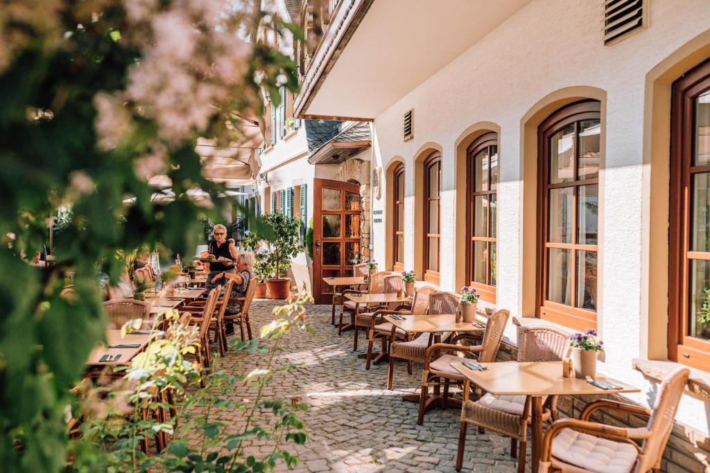 puste patio restauracji ze stołami i krzesłami w obiekcie Schmidtburger Hof w mieście Weiler