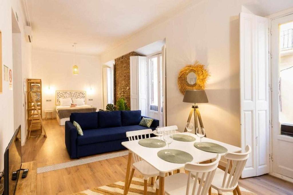 sala de estar con sofá azul y mesa en Strachan Apartamentos en el corazón de Málaga, en Málaga