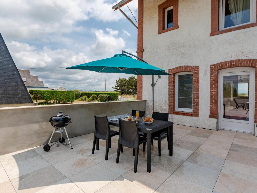 patio con tavolo, ombrellone blu e griglia di Apartment Sù la plage by Interhome a Portbail