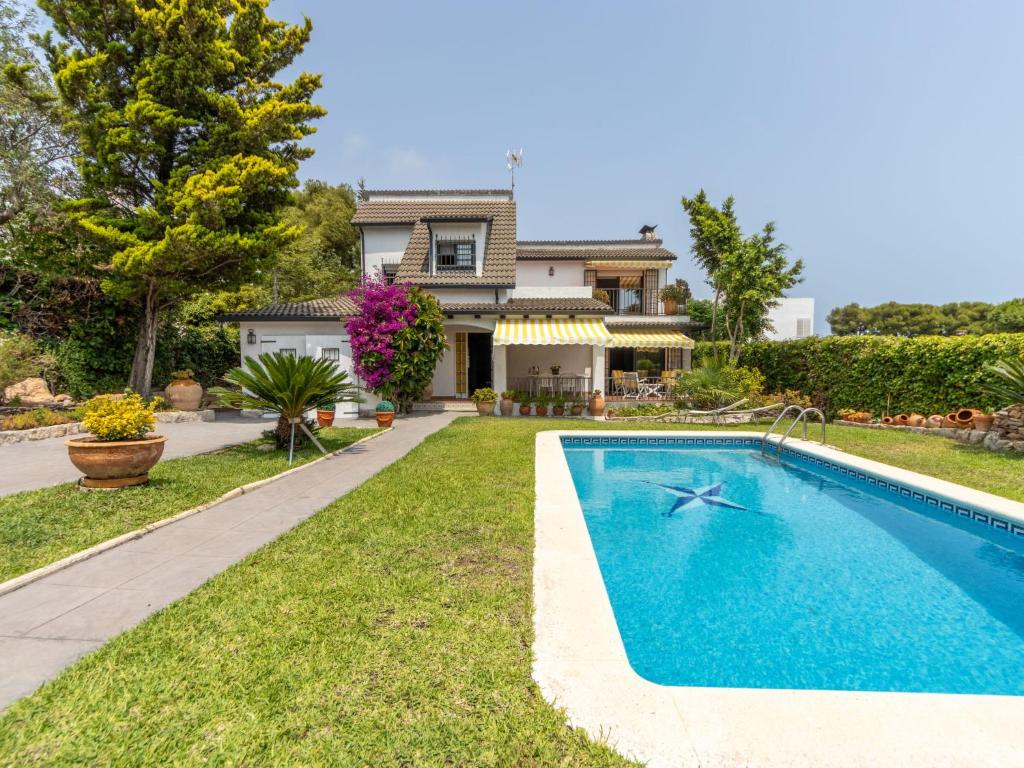 a swimming pool in front of a house at Holiday Home El Garrofer by Interhome in Comarruga