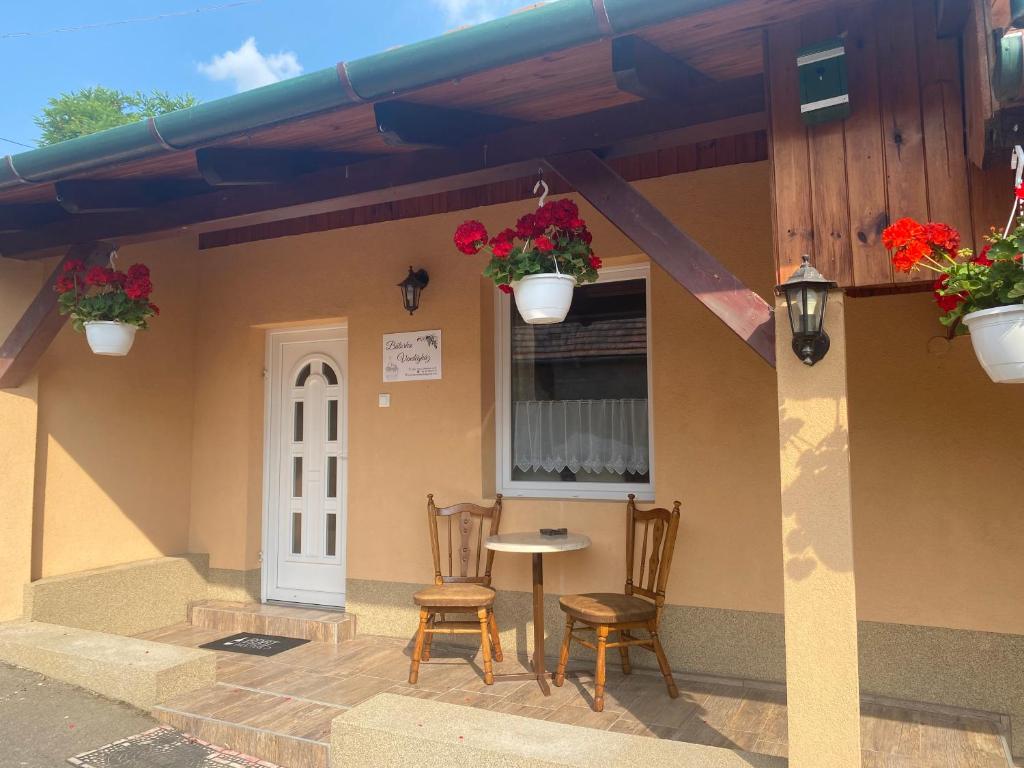 a house with two chairs and a table and a window at Bátorka Vendégház in Tállya