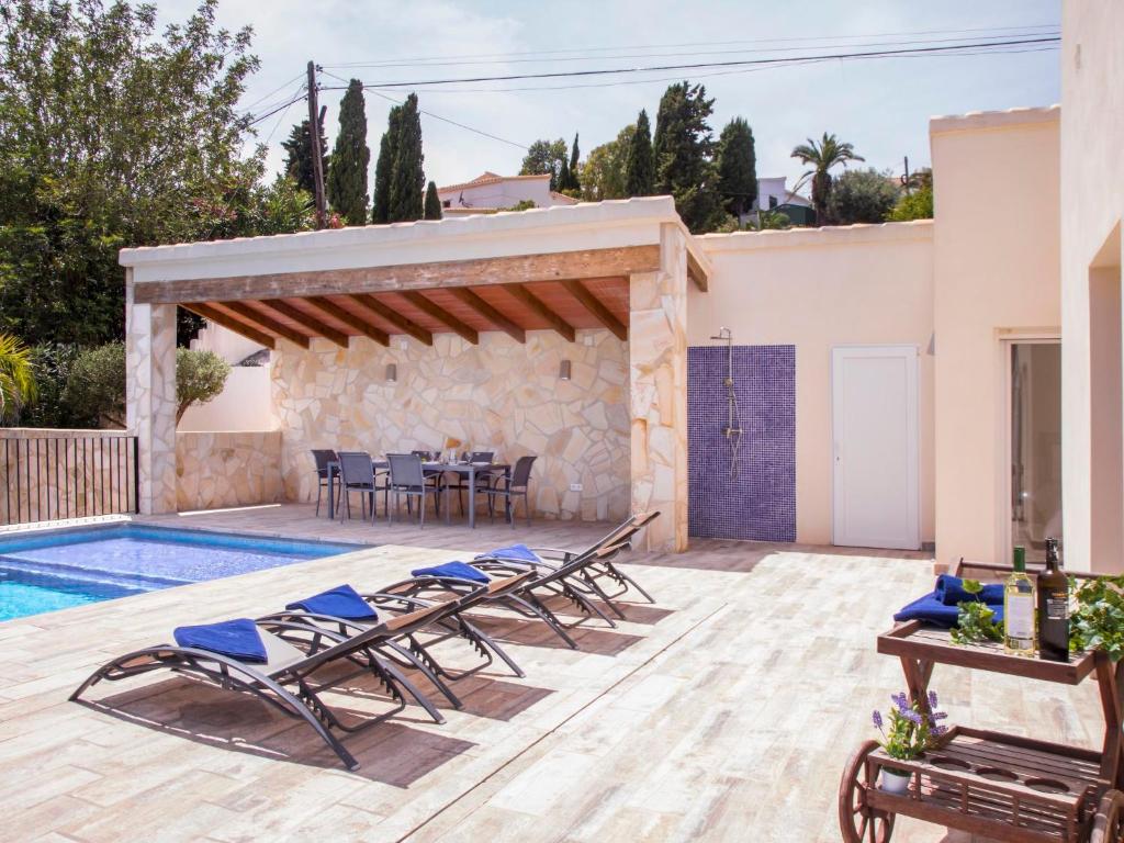 a patio with chairs and a table and a pool at Holiday Home Baruffa by Interhome in Jávea