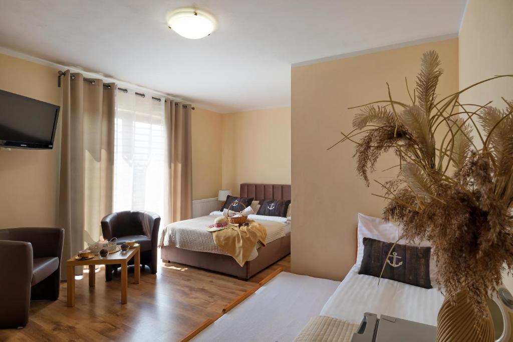 um quarto com uma cama e uma sala de estar em Willa Kapitańska i Willa Marynarska em Łeba