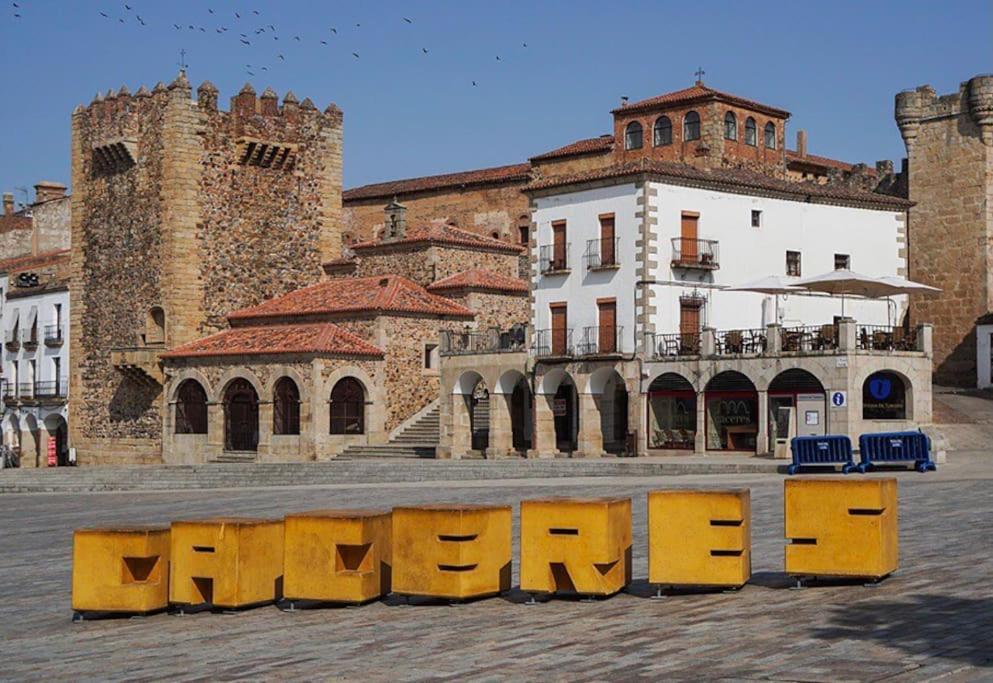 a large yellow sign in front of a building at Tu alojamiento en Cáceres in Cáceres
