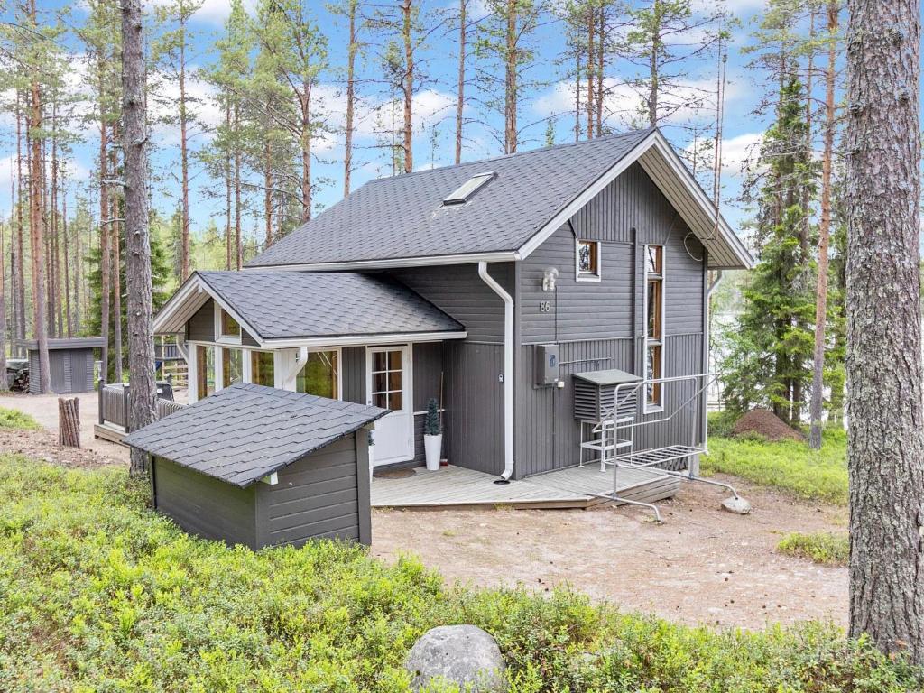 una casita gris con un porche en el bosque en Holiday Home Alakitkanranta by Interhome, en Kuusamo