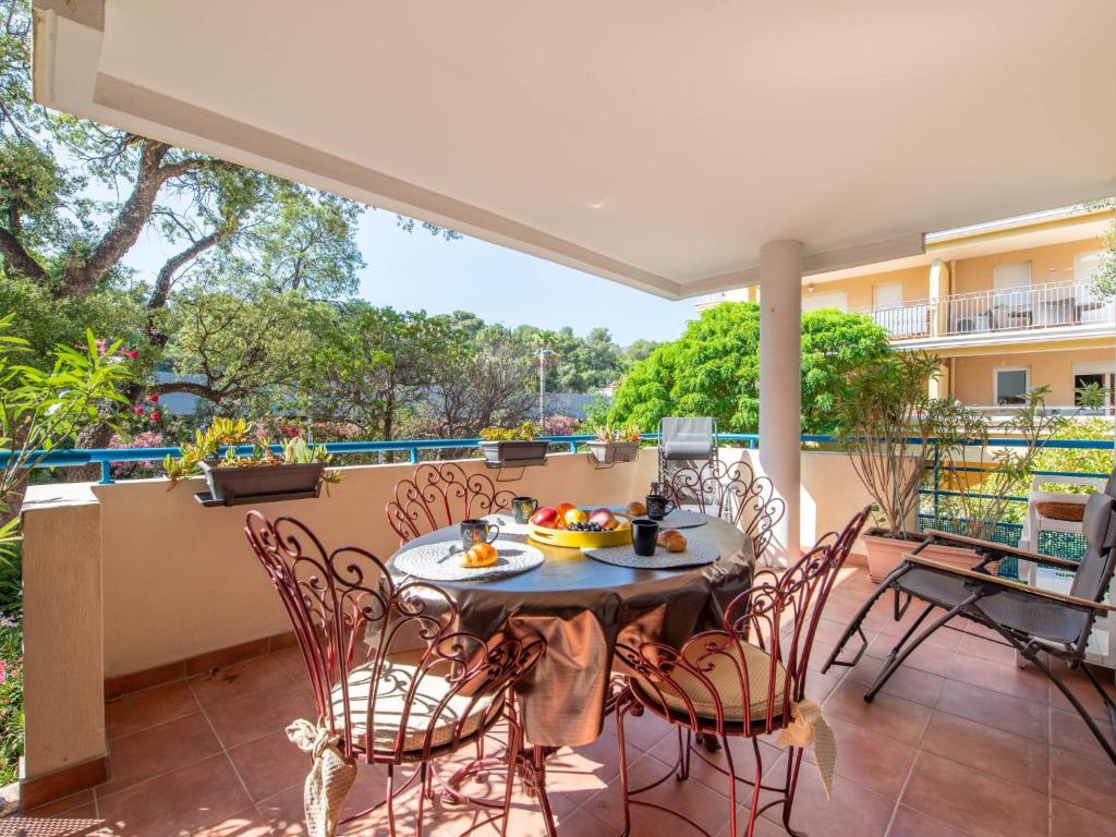 un patio avec une table et des chaises sur un balcon dans l'établissement Apartment Le Cap Sud by Interhome, à Cavalaire-sur-Mer