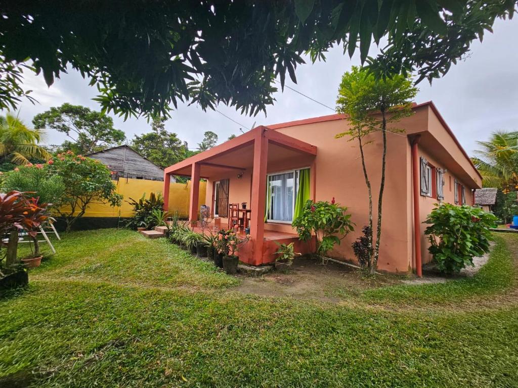 ein kleines Haus in einem Hof mit einem Rasenplatz in der Unterkunft LA MARINA in Ambodifototra