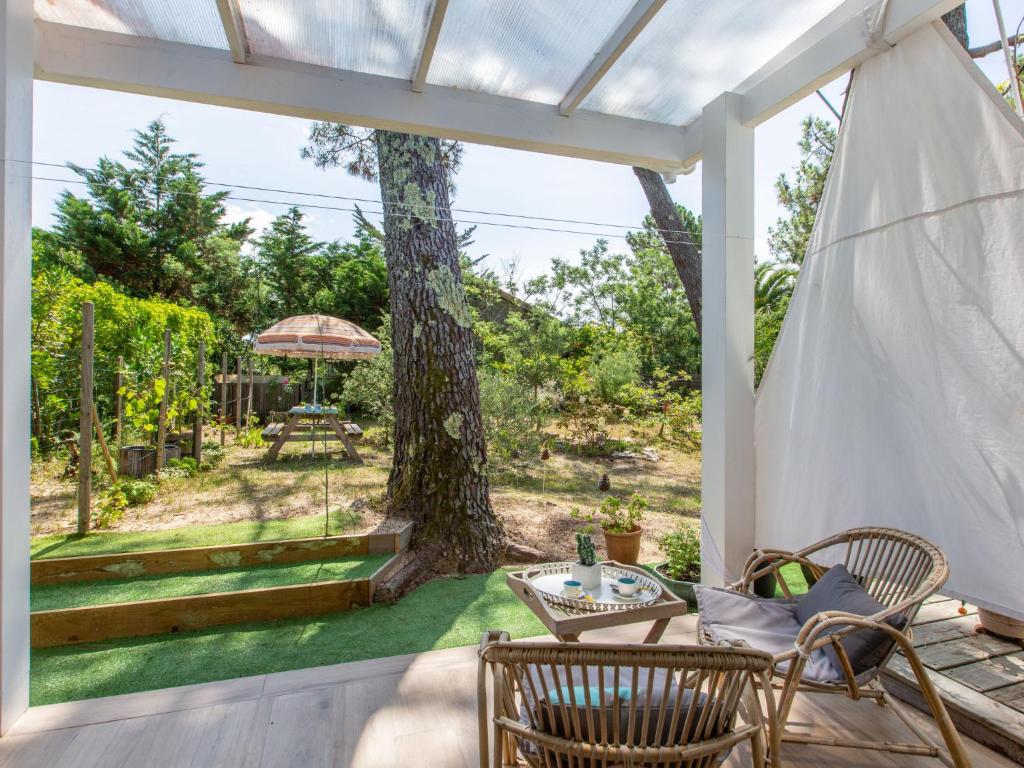 d'une terrasse avec une table, des chaises et un arbre. dans l'établissement Studio Biarritz by Interhome, à Capbreton