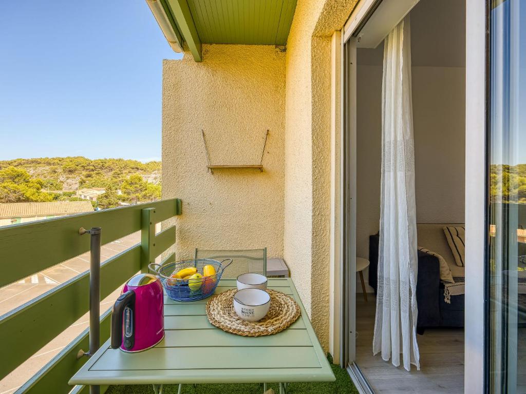 a table on a balcony with a bowl of fruit at Apartment Les Pins by Interhome in Narbonne-Plage