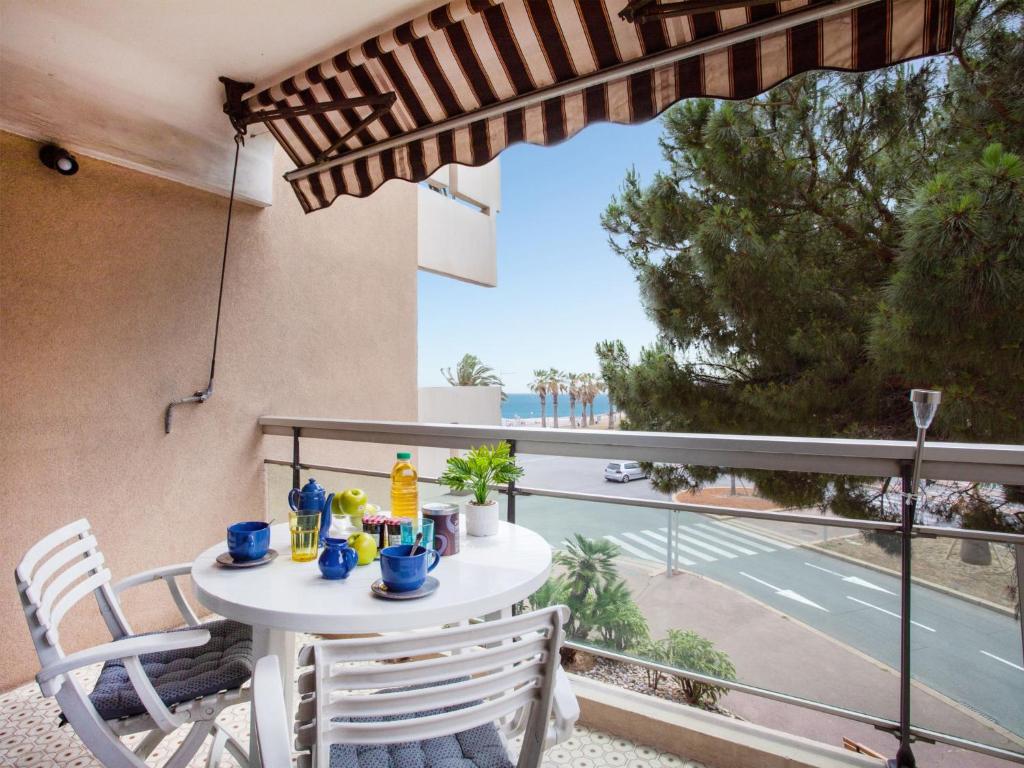 d'une table et de chaises sur un balcon avec vue sur la rue. dans l'établissement Studio Le Tiercé by Interhome, à Cagnes-sur-Mer