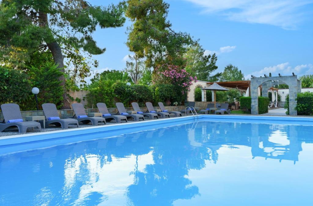 een zwembad met ligstoelen en bomen bij Stefania Hotel in Amarinthos